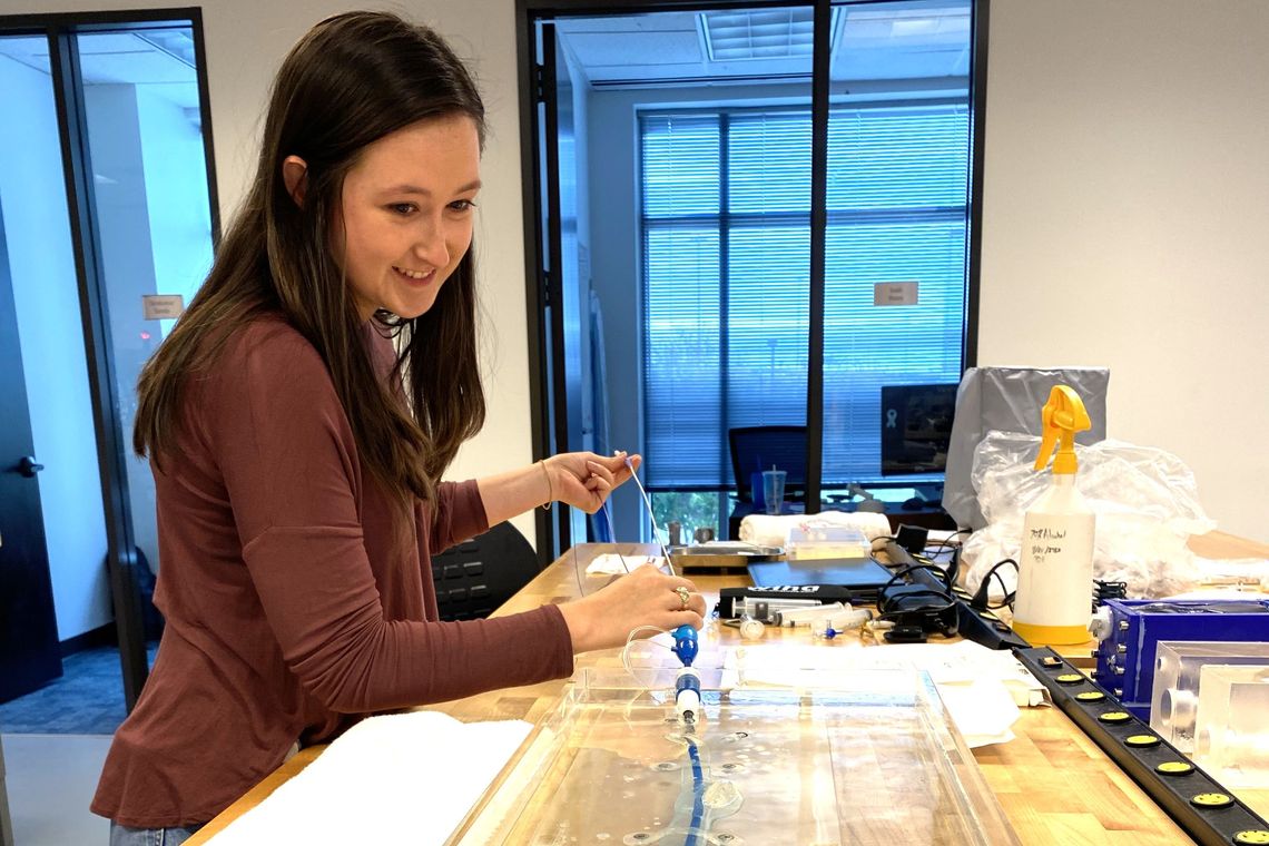 intern working with a machine submerged in water
